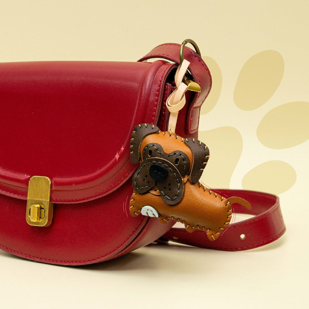Red handbag with a brown dog-shaped strap accessory on a beige background