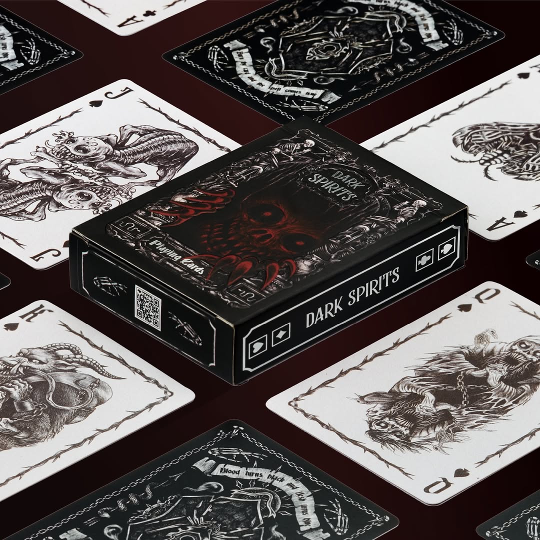 Dark Spirits playing cards with black and white designs on a dark surface